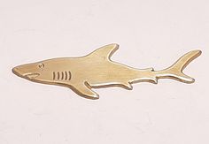 a gold shark shaped object on a white surface