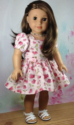 the doll is wearing a pink dress and white shoes