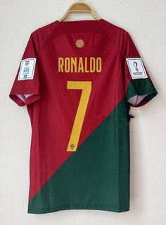 a red and green soccer jersey hanging on a hanger with the number seven printed on it