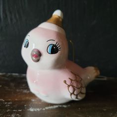 a pink ceramic bird with a gold crown on its head