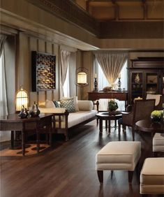 a living room filled with lots of furniture and decor on top of hard wood flooring