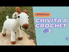 a crocheted animal is standing on top of a piece of wood with the words hermosa written above it