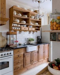 a kitchen filled with lots of wooden cabinets and counter top next to a white stove top oven