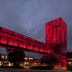 a tall red tower sitting under a cloudy sky