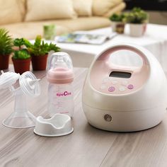 a baby bottle sitting on top of a wooden table next to a humider and potted plant