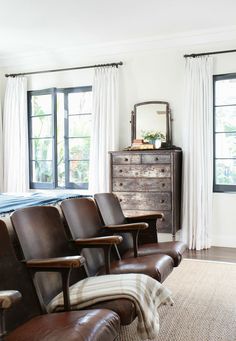 an empty room with leather chairs and a dresser