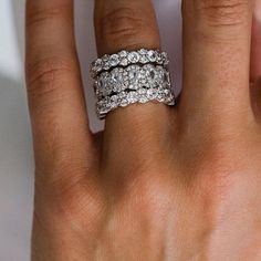 a woman's hand with two wedding rings on her left and the middle finger