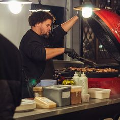 a man cooking food on top of a grill