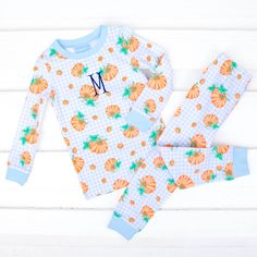 Could this print be any cuter for the season? Your pumpkin will stay comfy and cozy all fall long! Your little one will be comfortable in our Pumpkin Print Light Blue Gingham Pajamas. These charming pajamas feature an adorable pumpkin print, making them a fun and stylish choice for bedtime. The set includes a warm long-sleeve pajama top and matching pull-on pajama pants, providing the perfect combination of comfort and warmth. Personalize these pajamas with a monogram for an adorable touch! Whet Gingham Pajamas, Light Blue Gingham, Knit Loungewear, Bubble Dress, Pumpkin Print, Blue Gingham, Pajama Top, Long Sleeve Pyjamas, Mommy And Me