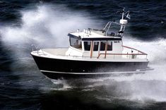 a black and white boat in the ocean with water splashing around it's sides