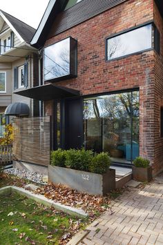 a brick house with lots of windows and landscaping