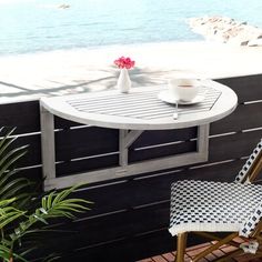 a table and chairs on a balcony overlooking the ocean