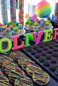 a table topped with lots of cupcakes and cookies next to the word solver