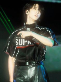 a man in black leather pants and a t - shirt with the word supreme on it