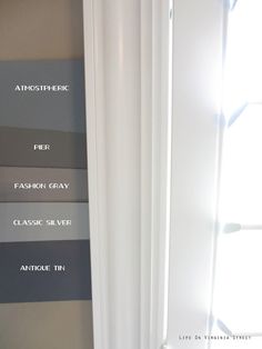 four different shades of gray paint on the wall in a room with white trim and windows