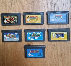 six nintendo gameboy games sitting on top of a wooden table