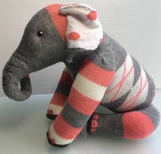 an elephant stuffed animal sitting on top of a white table next to a gray wall