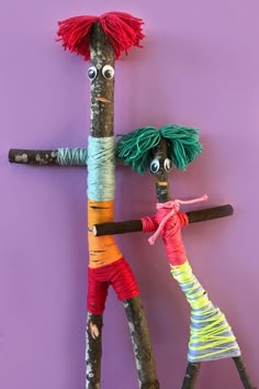 two wooden sticks with yarn on them and eyes