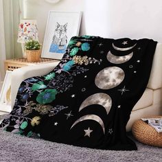 a bed covered in a black blanket with moon and stars on it