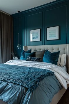 a bed with blue and white pillows in a bedroom next to a large window on the wall