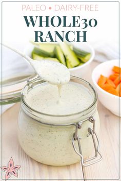 a spoon full of ranch dressing with cucumbers and carrots in the background