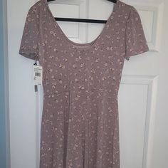 a dress hanging on a hanger in front of a door with a tag attached to it