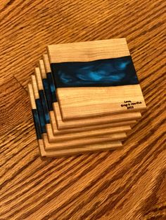 five wooden coasters sitting on top of a wooden table with blue and black designs