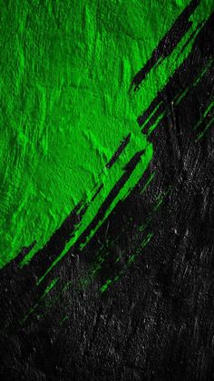 a green and black wall with some paint on it's surface, as well as the