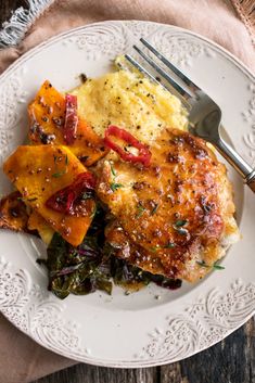 a white plate topped with meat and veggies on top of a wooden table