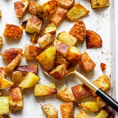 cooked potatoes on a baking sheet with a spatula