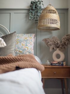 a bed room with a neatly made bed and two hanging baskets on the headboard