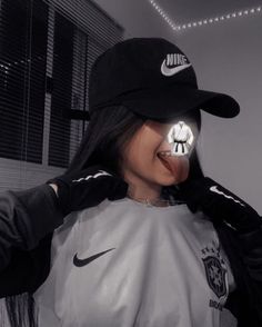 a woman wearing a nike hat with her face painted