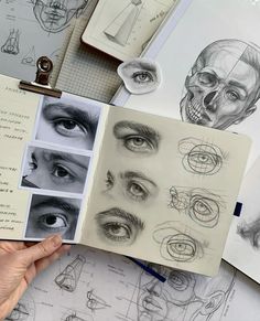 a person holding up a book with drawings on it and an eye in the middle