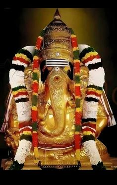 the statue of lord ganesha is adorned with flowers and garlands