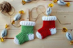 two crocheted christmas stockings and some candy on a wooden table with twine