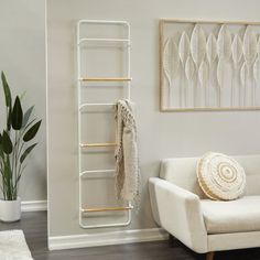 a living room with a white couch, chair and wall hanging rack in the corner