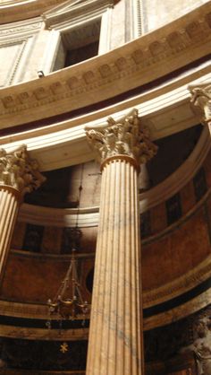 the inside of a building with columns and chandelier