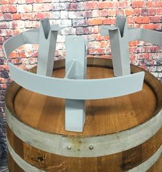 a wooden barrel with some metal brackets on it's side and a brick wall in the background