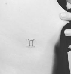 a small tattoo on the back of a woman's neck, with an i - letter