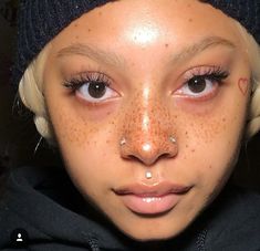 a close up of a person with freckles on her face and wearing a beanie