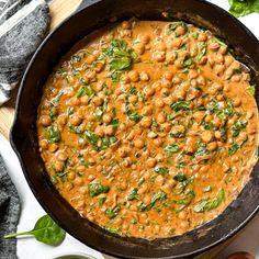 a skillet filled with chickpeas and spinach