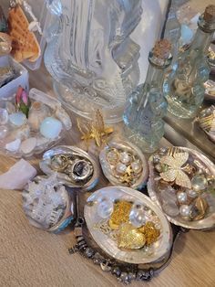 there are many different items on the table together, including glass bottles and seashells