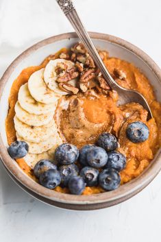 a bowl filled with oatmeal, bananas and blueberries