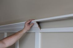 a man is painting the trim on a wall