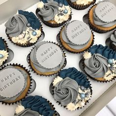 a box filled with cupcakes covered in frosting and decorated with blue icing