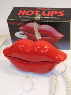 a red plastic mouth shaped object sitting on top of a white table next to a box