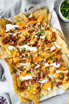 nachos topped with cheese, onions and sour cream