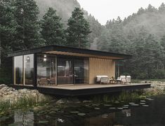 a small house sitting on top of a lake next to a forest filled with trees