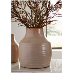 two vases with plants in them sitting on a table next to a window sill