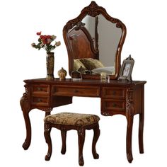 an ornate wooden vanity with mirror and stool